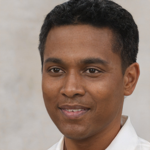 Joyful black young-adult male with short  black hair and brown eyes