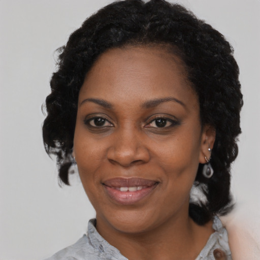 Joyful black adult female with short  black hair and brown eyes