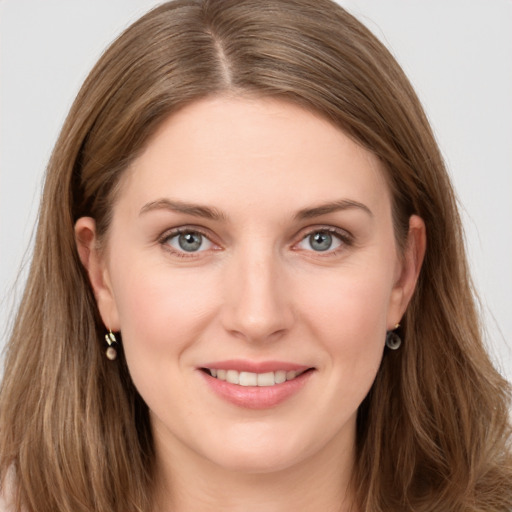 Joyful white young-adult female with long  brown hair and grey eyes