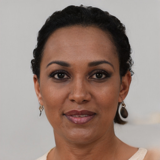Joyful black adult female with short  black hair and brown eyes