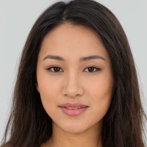 Joyful latino young-adult female with long  brown hair and brown eyes