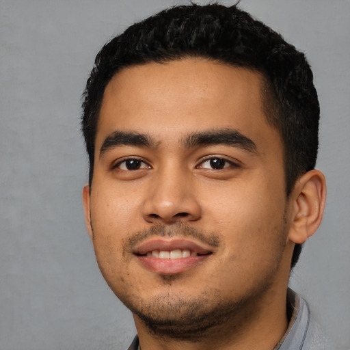 Joyful latino young-adult male with short  black hair and brown eyes