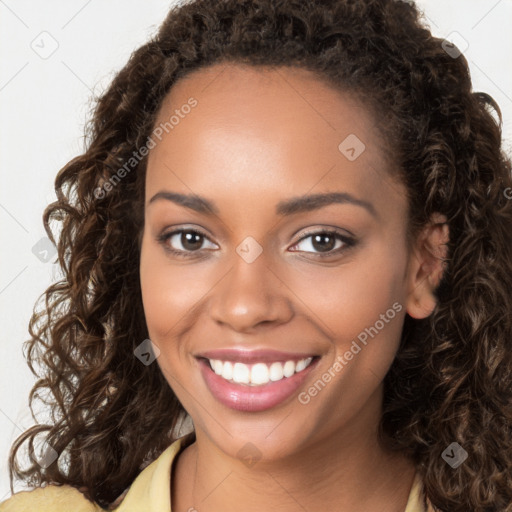 Joyful black young-adult female with long  brown hair and brown eyes