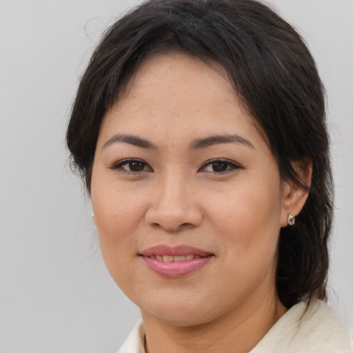 Joyful asian adult female with medium  brown hair and brown eyes