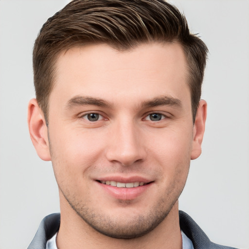 Joyful white young-adult male with short  brown hair and grey eyes