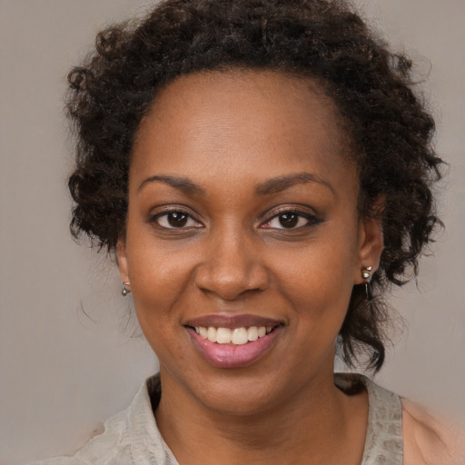 Joyful black young-adult female with medium  brown hair and brown eyes