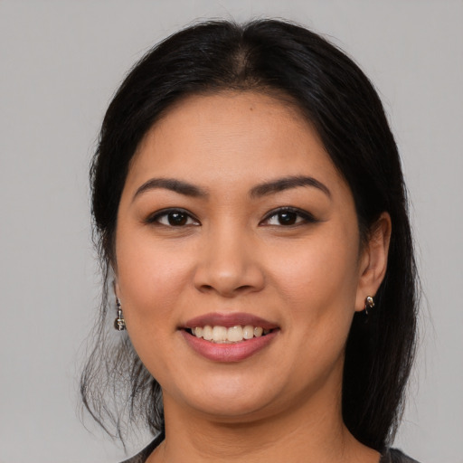Joyful latino young-adult female with long  brown hair and brown eyes