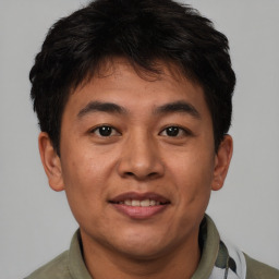 Joyful asian young-adult male with short  brown hair and brown eyes