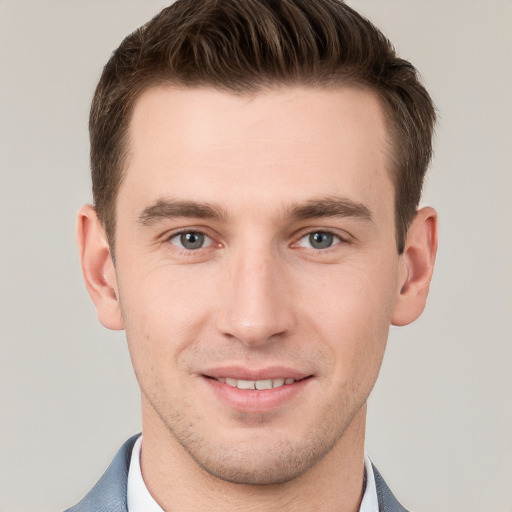 Joyful white young-adult male with short  brown hair and grey eyes