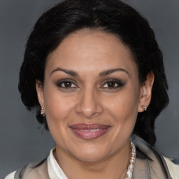 Joyful latino adult female with medium  brown hair and brown eyes