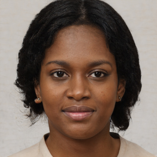 Joyful black young-adult female with medium  black hair and brown eyes