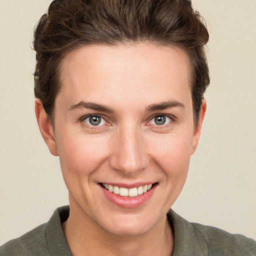 Joyful white young-adult female with short  brown hair and grey eyes