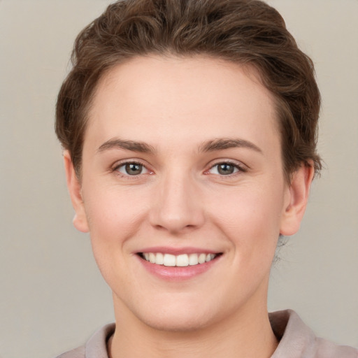 Joyful white young-adult female with short  brown hair and grey eyes