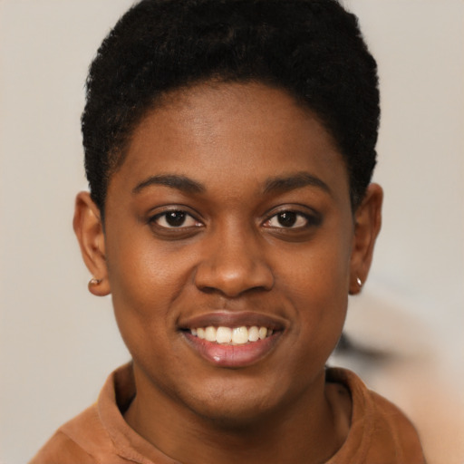 Joyful black young-adult female with short  brown hair and brown eyes
