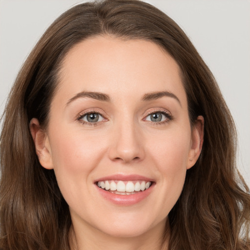 Joyful white young-adult female with long  brown hair and grey eyes