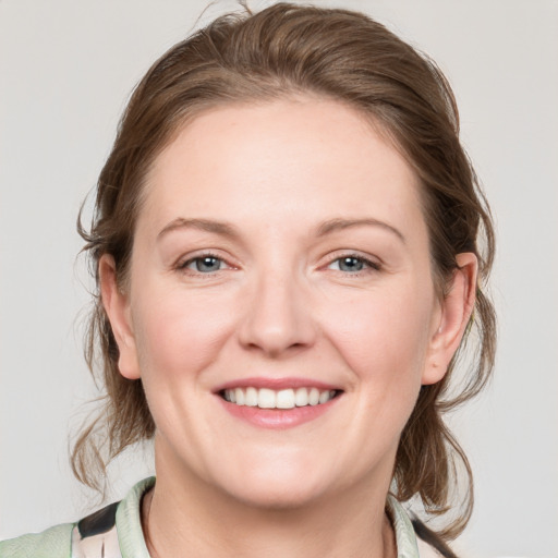 Joyful white adult female with medium  brown hair and blue eyes