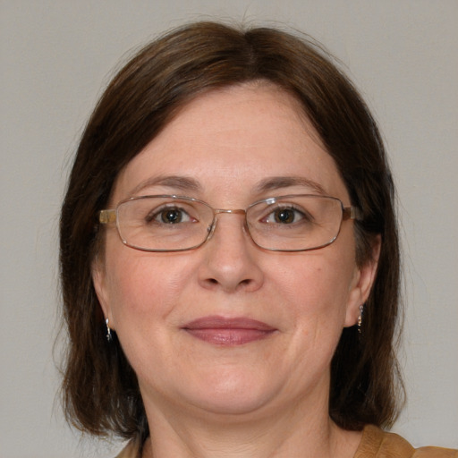 Joyful white adult female with medium  brown hair and blue eyes