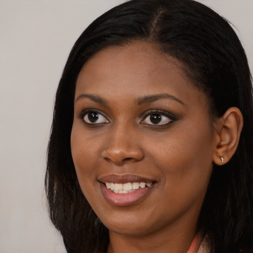 Joyful black young-adult female with long  brown hair and brown eyes