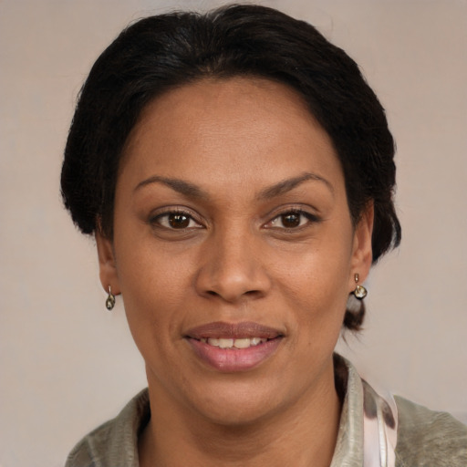 Joyful latino adult female with medium  brown hair and brown eyes