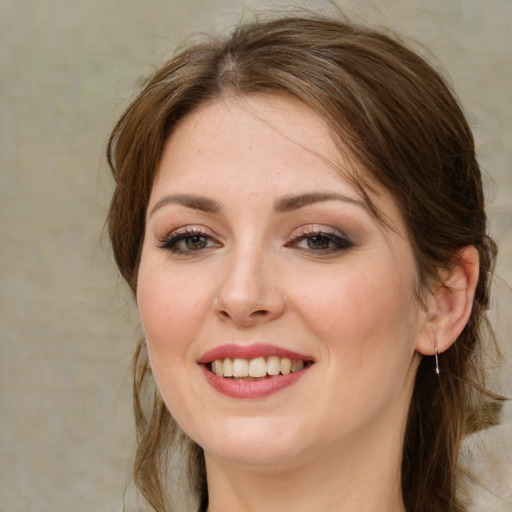 Joyful white young-adult female with medium  brown hair and green eyes