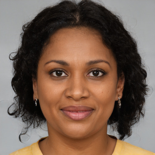 Joyful black young-adult female with medium  brown hair and brown eyes