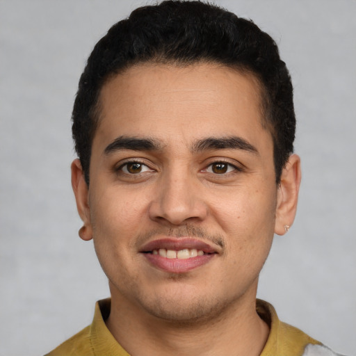 Joyful latino young-adult male with short  black hair and brown eyes