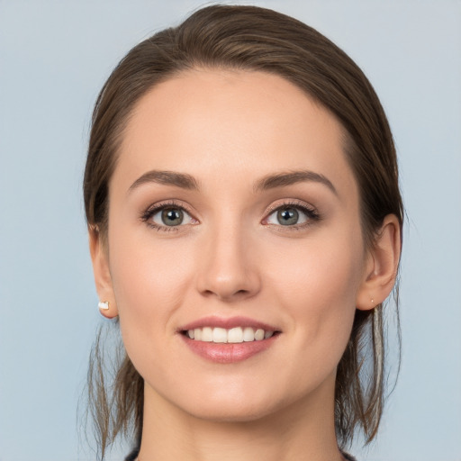 Joyful white young-adult female with medium  brown hair and grey eyes