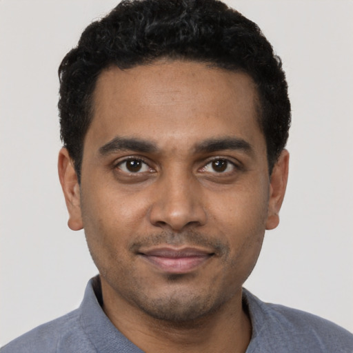 Joyful black young-adult male with short  black hair and brown eyes