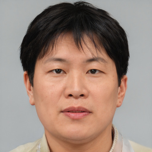 Joyful asian adult male with short  brown hair and brown eyes