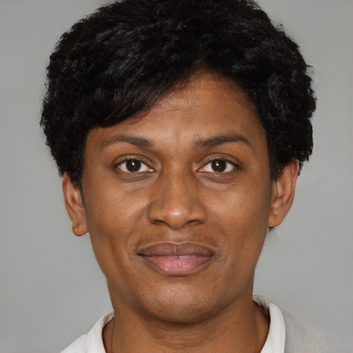 Joyful black young-adult female with short  black hair and brown eyes