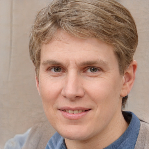 Joyful white adult male with medium  brown hair and blue eyes