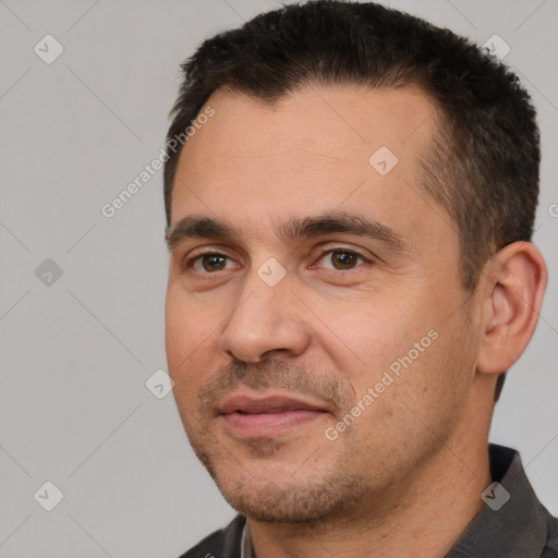 Joyful white adult male with short  black hair and brown eyes