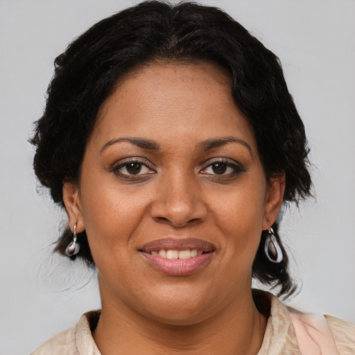 Joyful black adult female with medium  brown hair and brown eyes