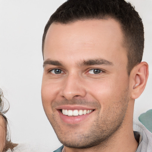 Joyful white young-adult male with short  brown hair and brown eyes