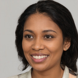 Joyful black young-adult female with medium  brown hair and brown eyes