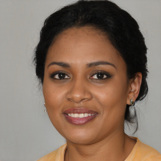 Joyful black young-adult female with medium  black hair and brown eyes