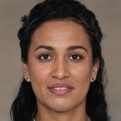 Joyful black young-adult female with long  black hair and brown eyes