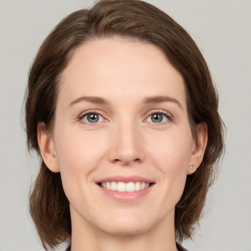 Joyful white young-adult female with medium  brown hair and green eyes