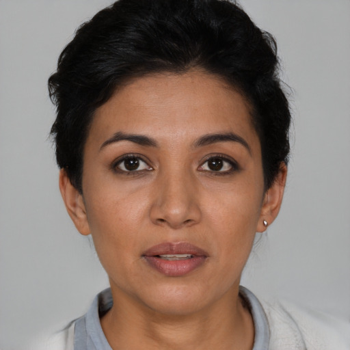 Joyful latino young-adult female with short  black hair and brown eyes