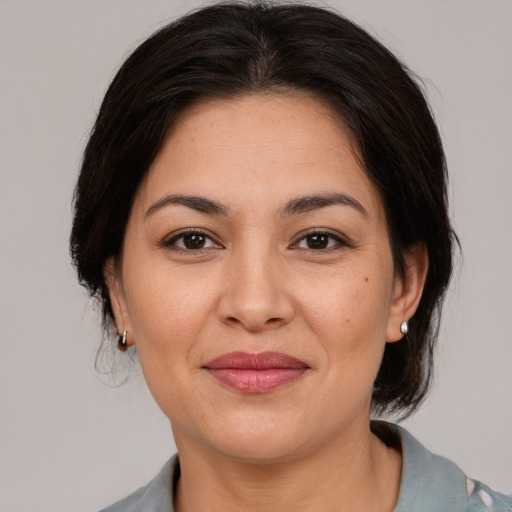 Joyful latino young-adult female with medium  brown hair and brown eyes