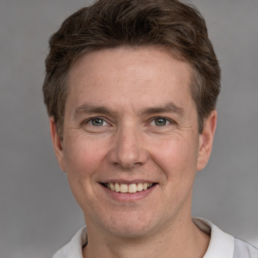 Joyful white adult male with short  brown hair and grey eyes