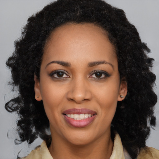 Joyful black young-adult female with long  black hair and brown eyes