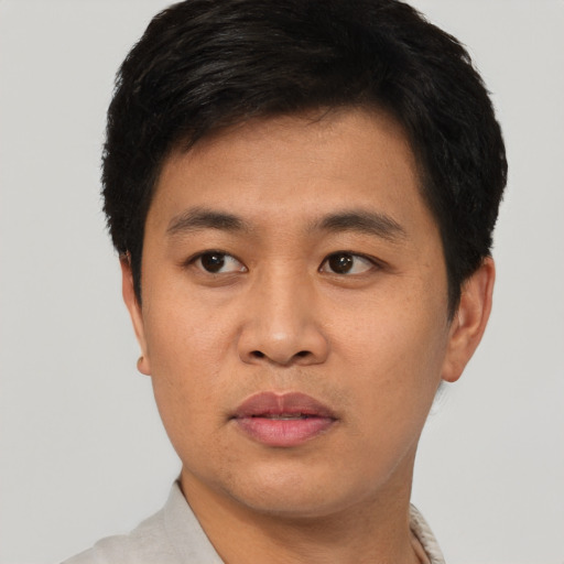 Joyful asian young-adult male with short  black hair and brown eyes