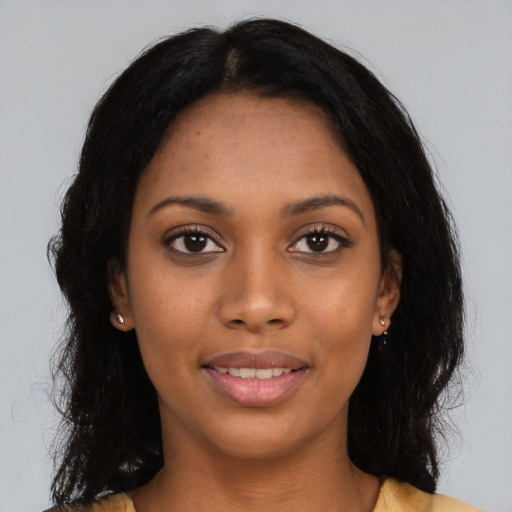 Joyful black young-adult female with long  black hair and brown eyes