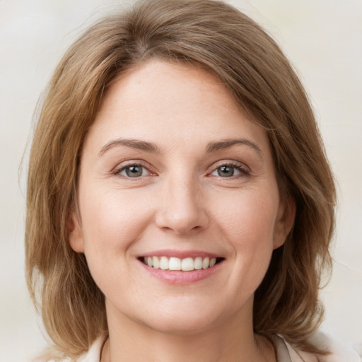 Joyful white young-adult female with medium  brown hair and green eyes