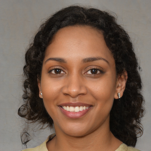 Joyful black young-adult female with medium  brown hair and brown eyes