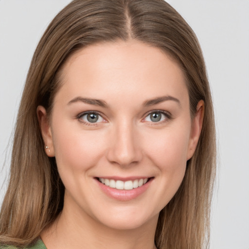 Joyful white young-adult female with long  brown hair and green eyes