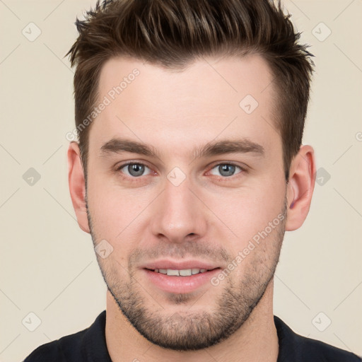 Joyful white young-adult male with short  brown hair and grey eyes