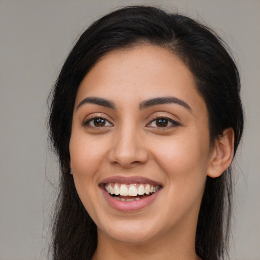 Joyful latino young-adult female with long  brown hair and brown eyes