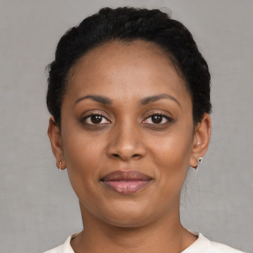 Joyful black young-adult female with short  brown hair and brown eyes